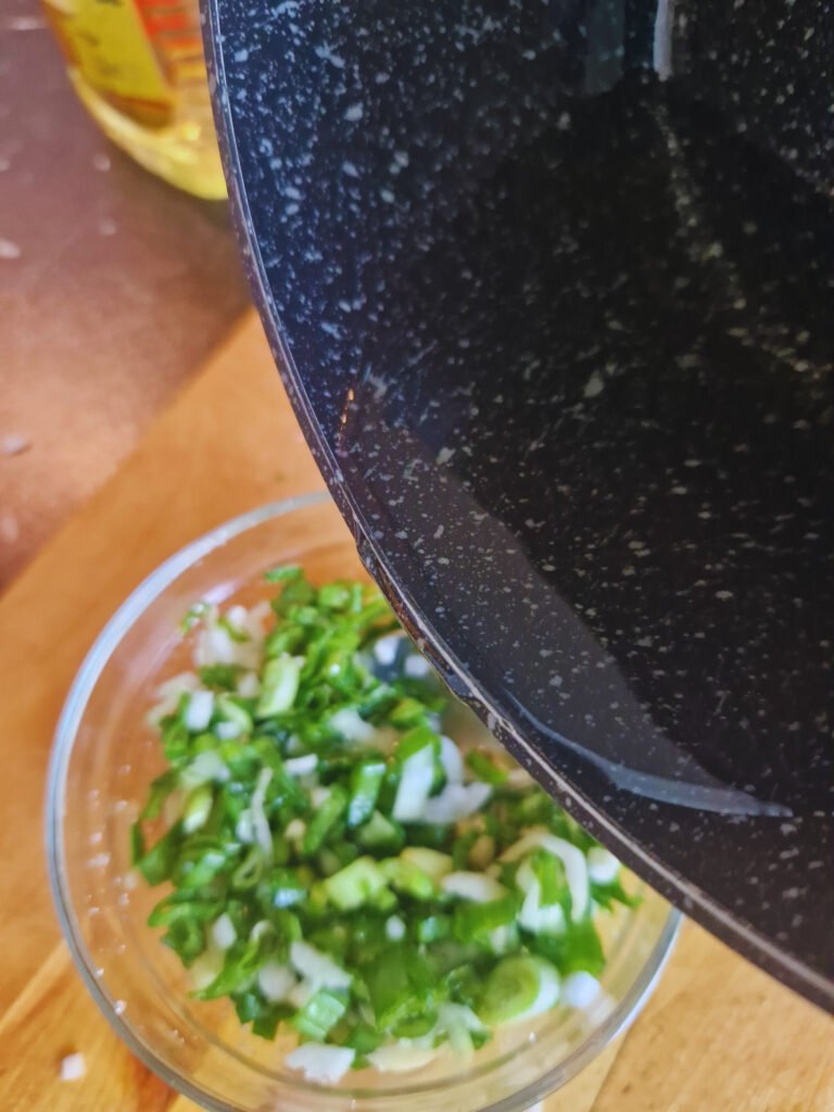 Pouring hot oil on ginger and scallions